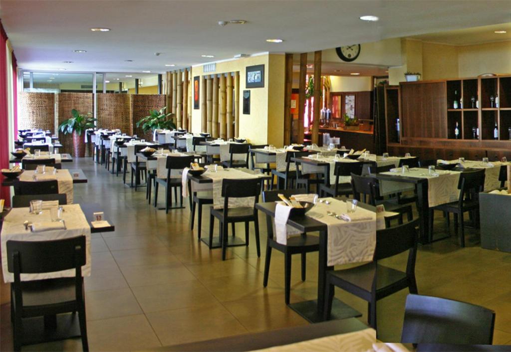 une salle à manger avec des tables et des chaises dans un restaurant dans l'établissement Hotel La Paül, à Sirmione
