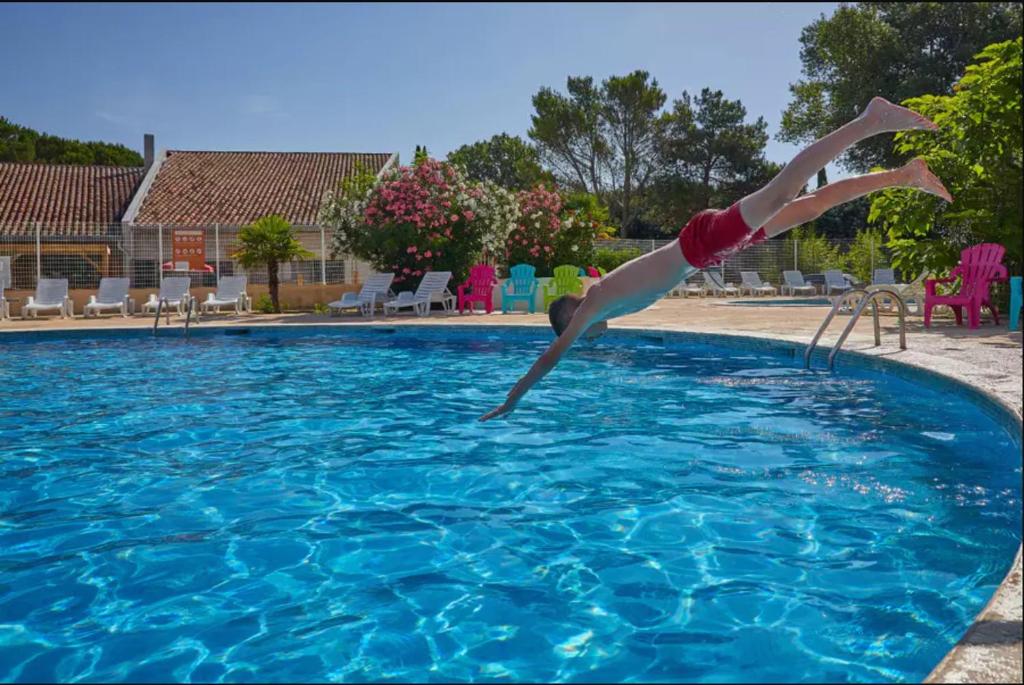 une personne plonge dans une piscine dans l'établissement Domaine des Iscles, à La Roque-dʼAnthéron