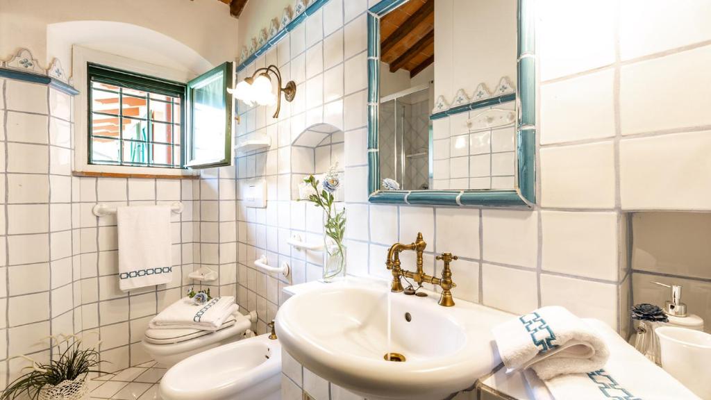 une salle de bain blanche avec un lavabo et des toilettes dans l'établissement Villa Elisa 16, Emma Villas, à Fucecchio