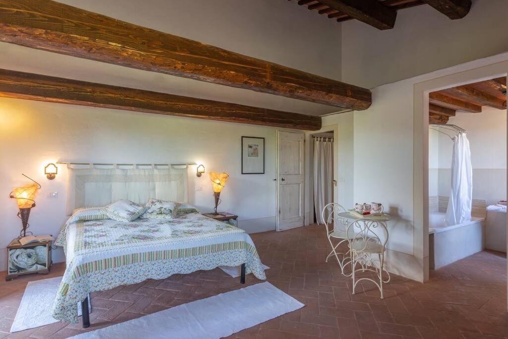 une chambre avec un grand lit et une table dans l'établissement Il Fosolo di Greppocornio, à Piegaro 49 autres photos