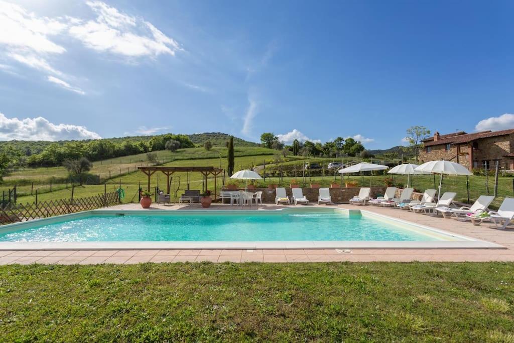 une piscine avec chaises et parasols dans l'établissement Il Fosolo di Greppocornio, à Piegaro