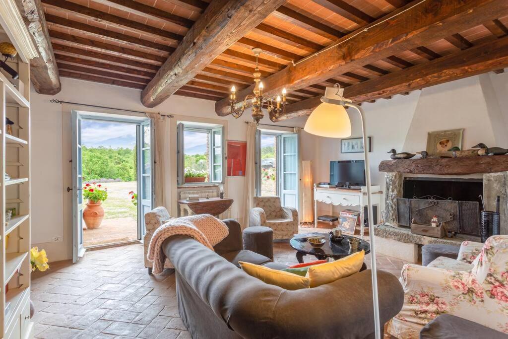 un salon avec un canapé et une cheminée dans l'établissement Il Fosolo di Greppocornio, à Piegaro