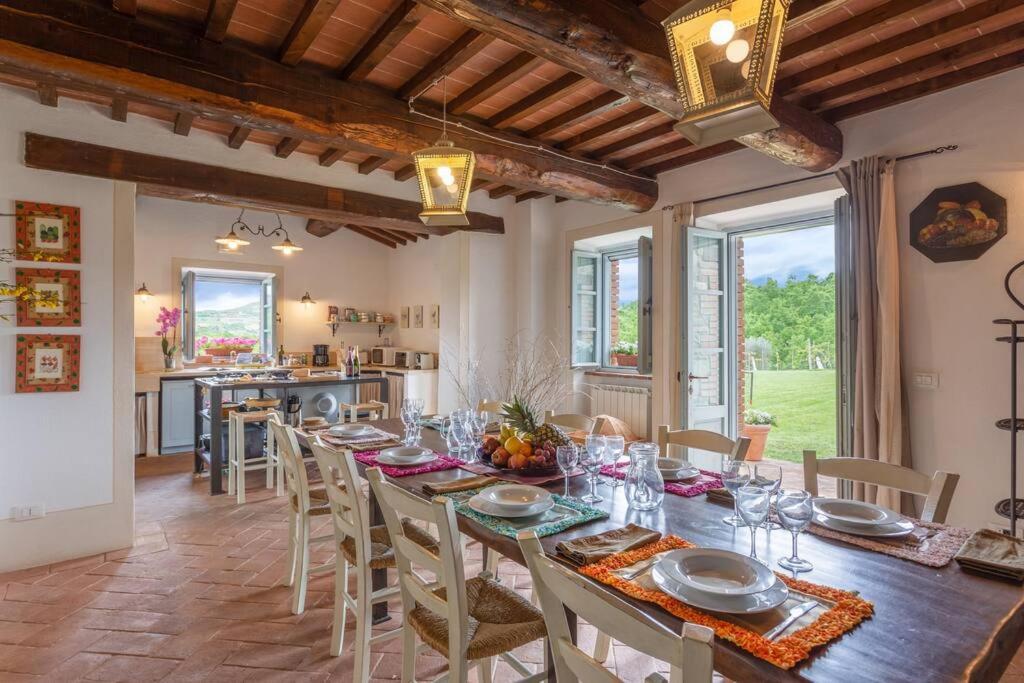 une grande salle à manger avec une longue table et des chaises dans l'établissement Il Fosolo di Greppocornio, à Piegaro