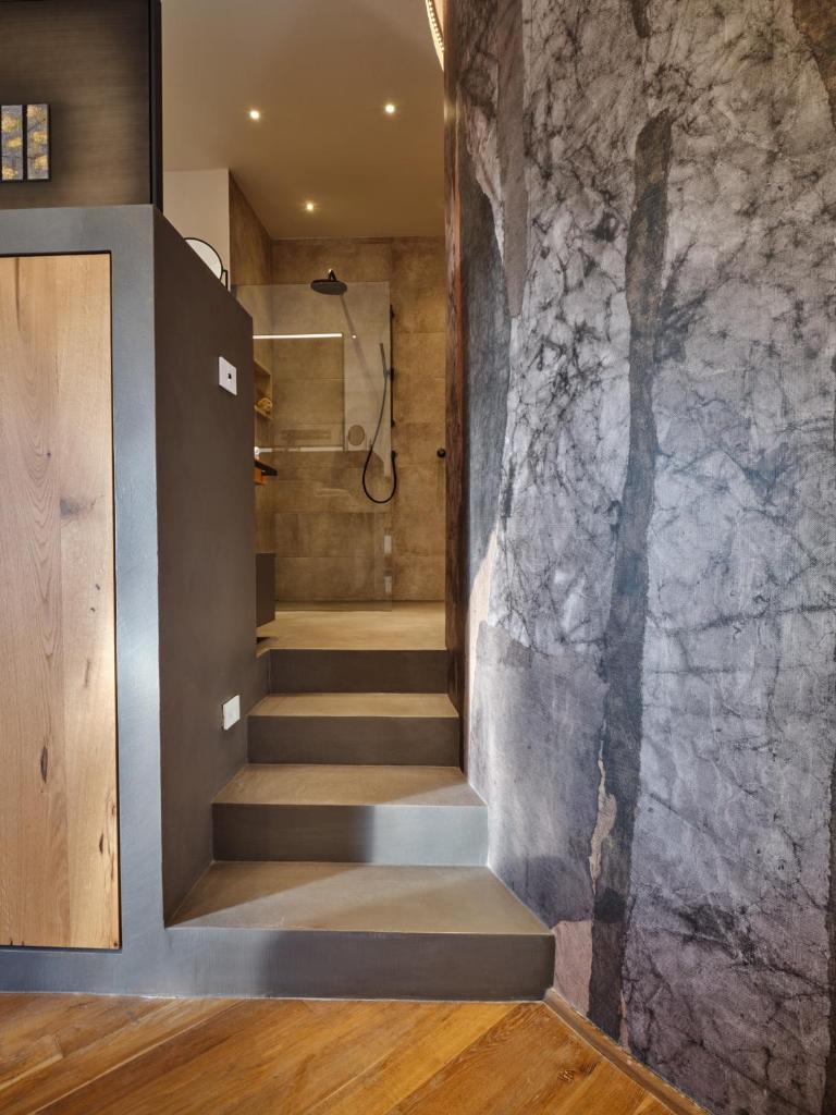 une salle de bain avec une douche à l'italienne à côté d'un mur en marbre dans l'établissement Il giardino sotto le stelle, à Fungaia