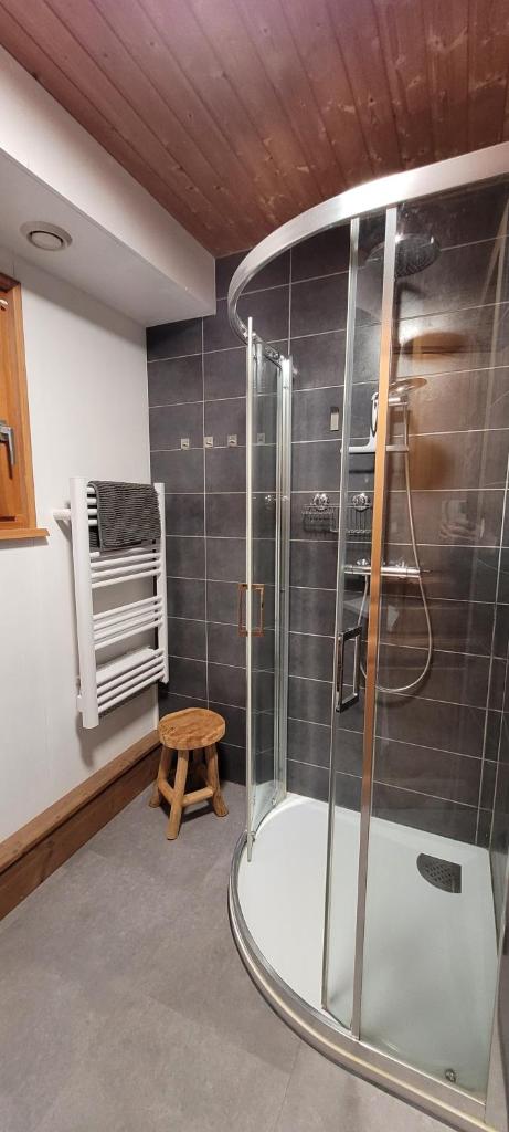 La salle de bains est pourvue d'une douche et d'un tabouret en bois. dans l'établissement Chalet de la Grimpette au coeur de Gérardmer, à Gérardmer