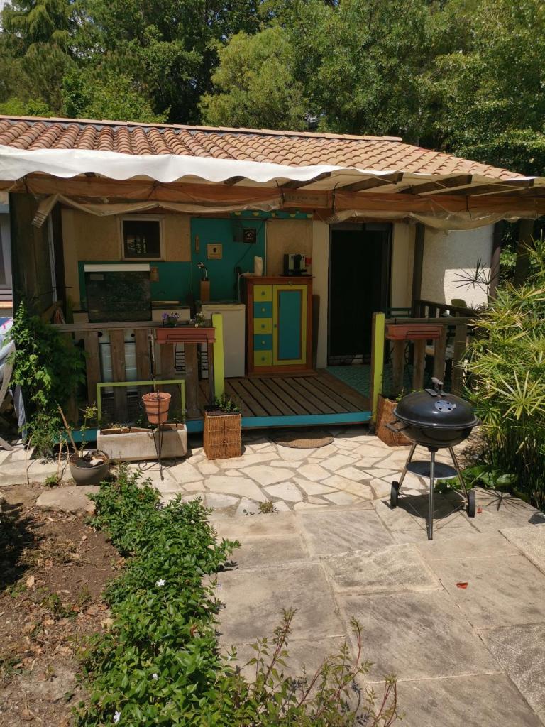une maison avec une terrasse et un grill en face de celle-ci dans l'établissement Le P'tit gîte, à Saint-Privat 5 autres photos