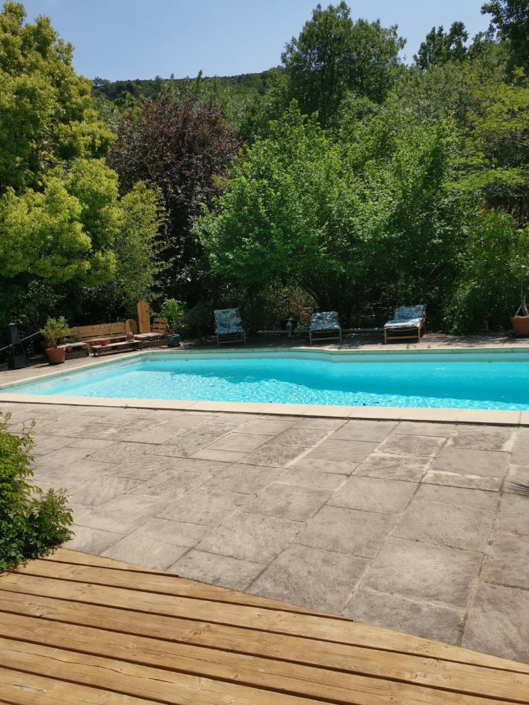 - une piscine avec 2 chaises dans l'établissement Le P'tit gîte, à Saint-Privat