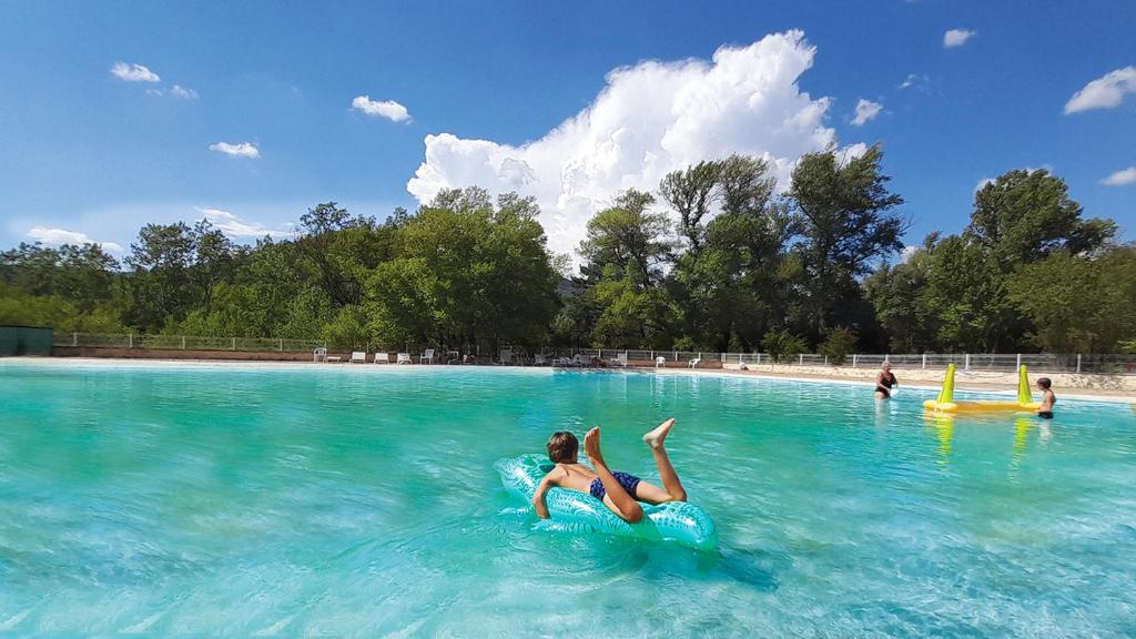 une femme posant sur un tube intérieur dans une piscine dans l'établissement Camping Tikayan La Célestine, à Beynes