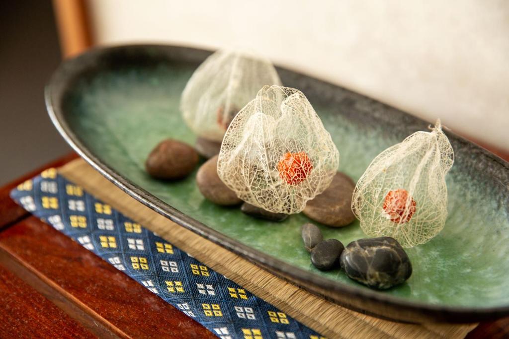 une assiette verte avec des pierres et des filets sur une table dans l'établissement Oyado Seri, à Toyooka