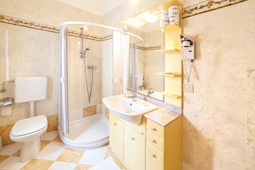 La salle de bains est pourvue d'une douche, de toilettes et d'un lavabo. dans l'établissement Hotel Villa Luisa, à Lignano Sabbiadoro