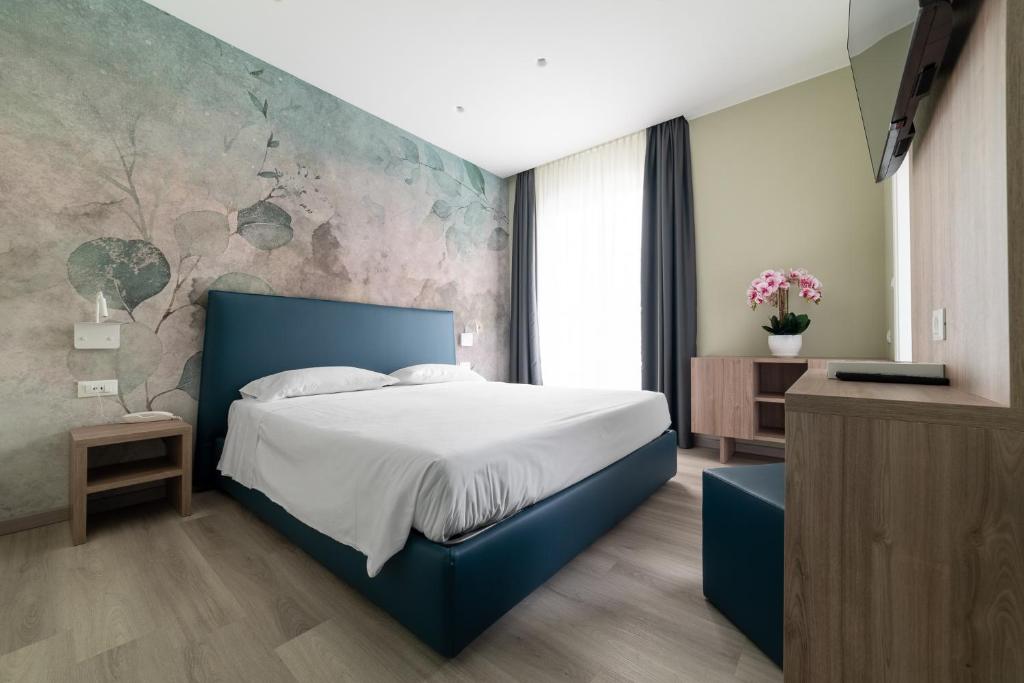 - une chambre avec un lit bleu et un mur en pierre dans l'établissement Hotel Colombo, à Lido di Jesolo 85 autres photos