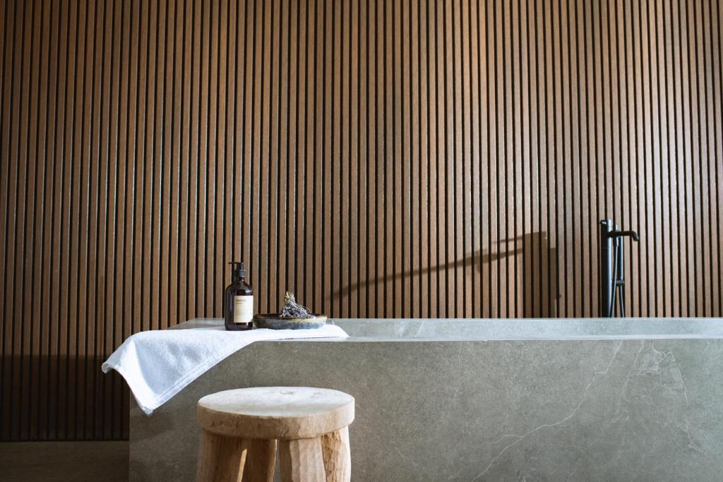 une baignoire avec une bouteille de vin et un tabouret dans l'établissement Residenza Cavaion, à Calmasino