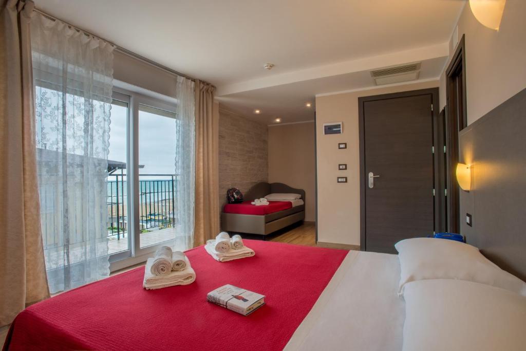 une chambre d'hôtel avec un lit, des serviettes et une fenêtre dans l'établissement Hotel London, à Cattolica