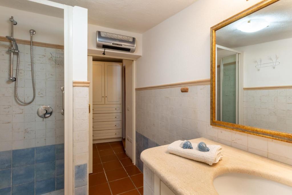 une salle de bain avec un lavabo, une douche et un miroir dans l'établissement Villa Campigiana, à Torre delle Stelle
