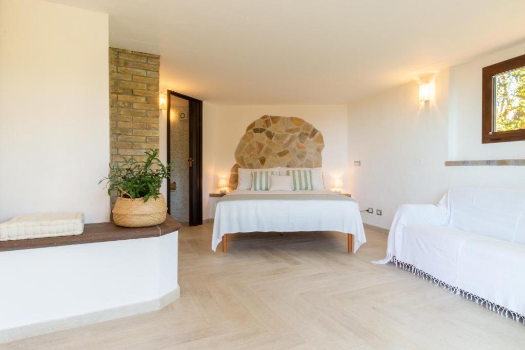 une chambre avec un lit blanc et un canapé blanc dans l'établissement Villa Campigiana, à Torre delle Stelle