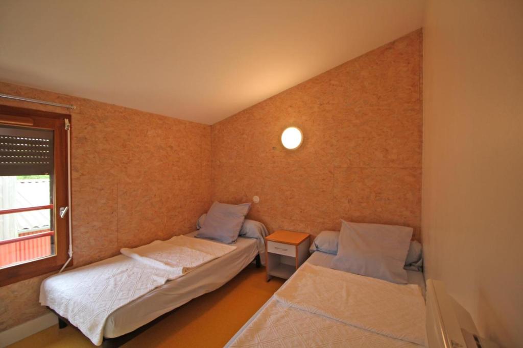 deux lits dans une petite pièce avec une fenêtre dans l'établissement Gîte La Chassagne - Gîte n°11, à Videix 10 autres photos