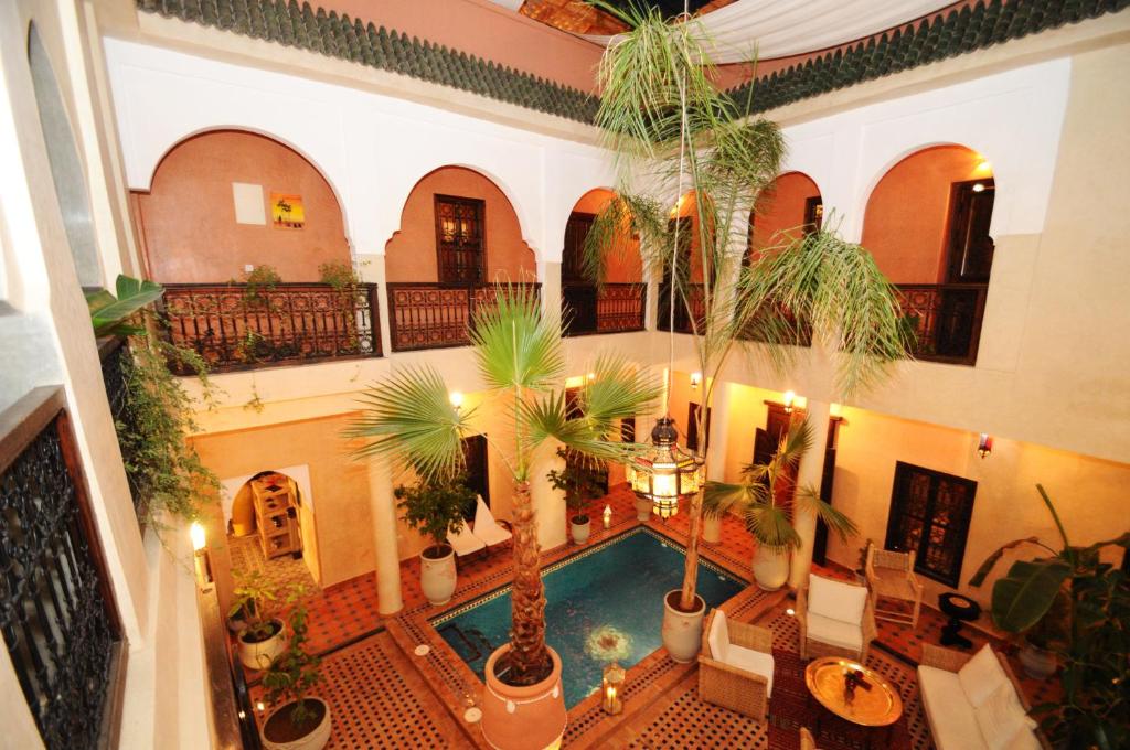 une piscine intérieure avec des palmiers dans un bâtiment dans l'établissement Riad Hadda, à Marrakech
