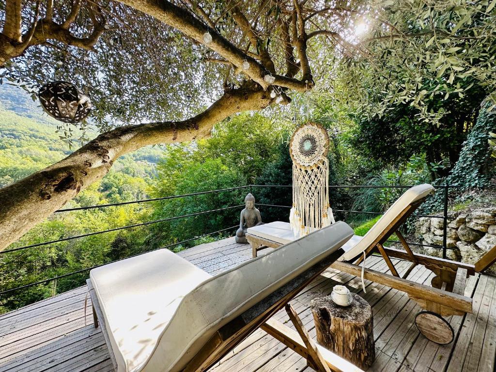 une terrasse avec un hamac et un arbre dans l'établissement Domaine Les Deux Roches, à Le Bar-sur-Loup