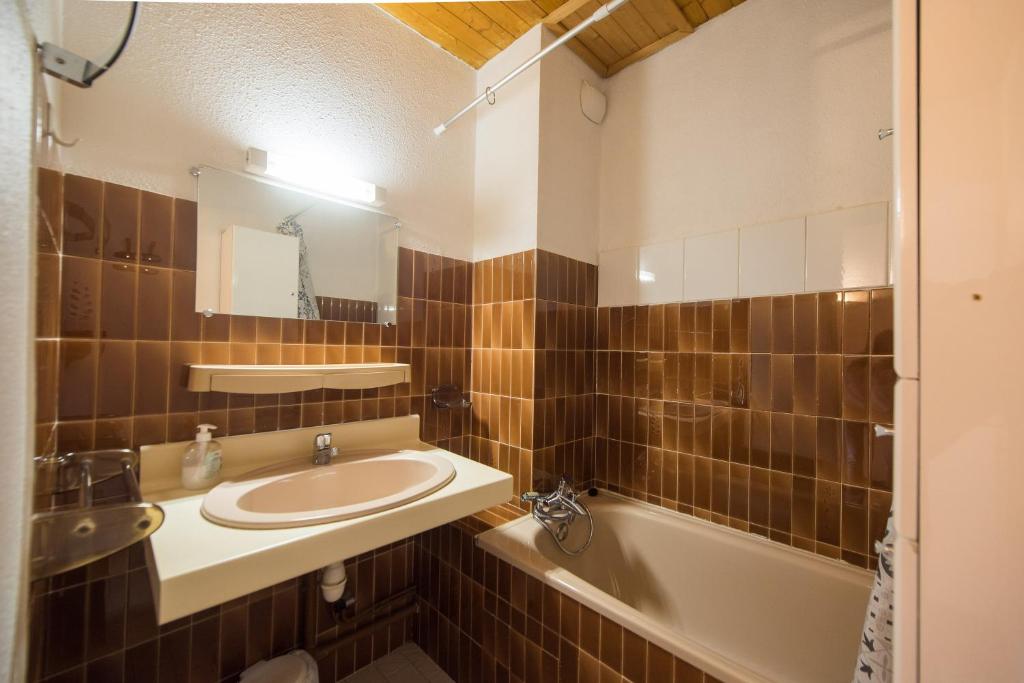 une salle de bain avec un lavabo et une baignoire dans l'établissement Serre-chevalier Vallée - Briançon, à Briançon