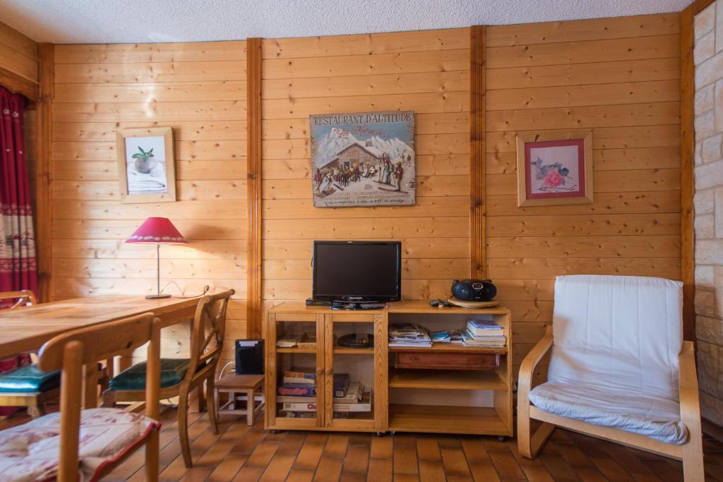 un salon avec une table et une télévision dans l'établissement Serre-chevalier Vallée - Briançon, à Briançon