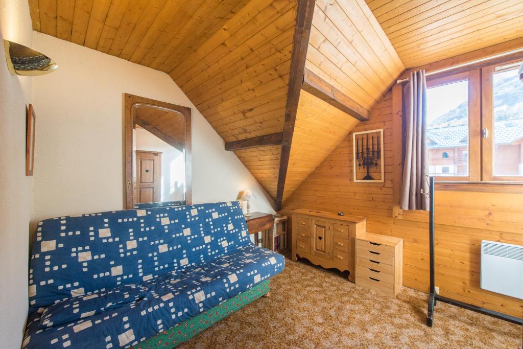 une chambre avec un lit et un plafond en bois dans l'établissement Serre-chevalier Vallée - Briançon, à Briançon