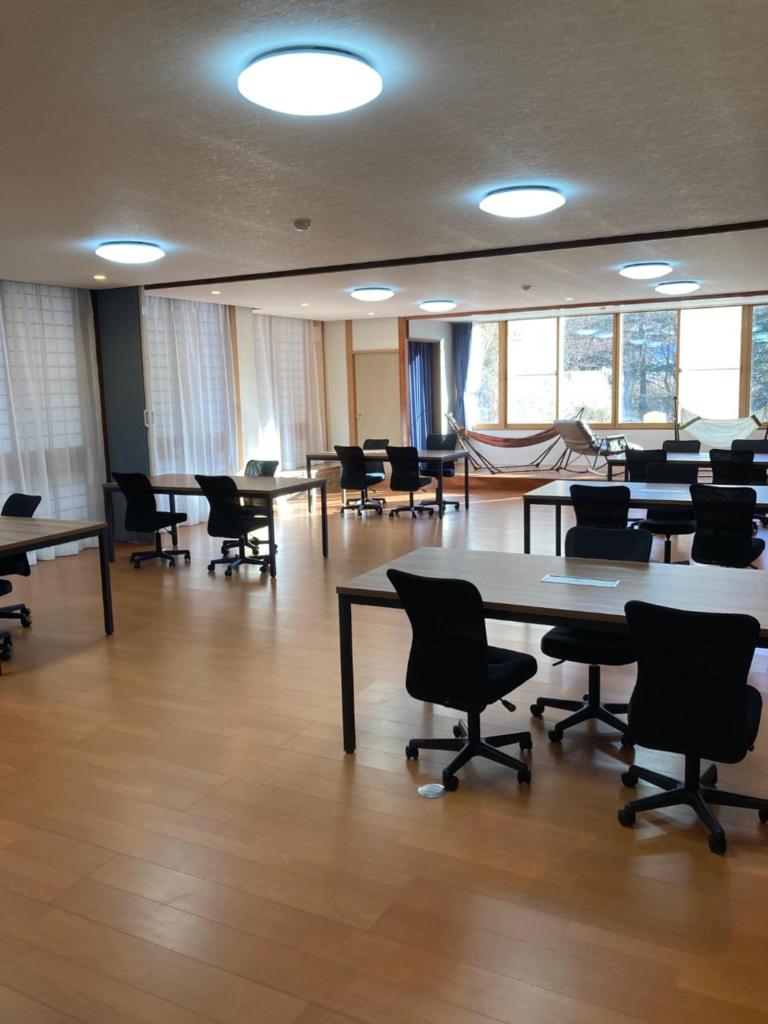 une grande pièce avec des tables, des chaises et des fenêtres dans l'établissement Ryokan Fujitomita, à Oshino 37 autres photos