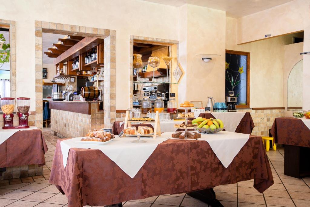 un restaurant avec une table avec de la nourriture dessus dans l'établissement Casa Merano Residence & Restaurant Bibione Centro, à Bibione