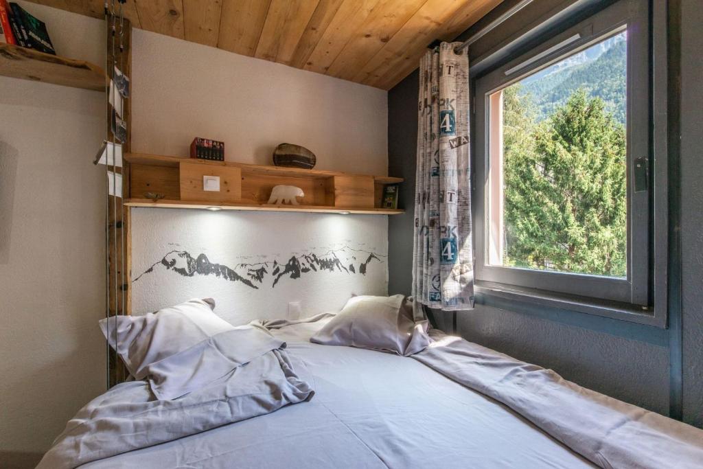 un lit dans une chambre avec une fenêtre dans l'établissement Modern Apt with Mont-Blanc view, à Chamonix-Mont-Blanc