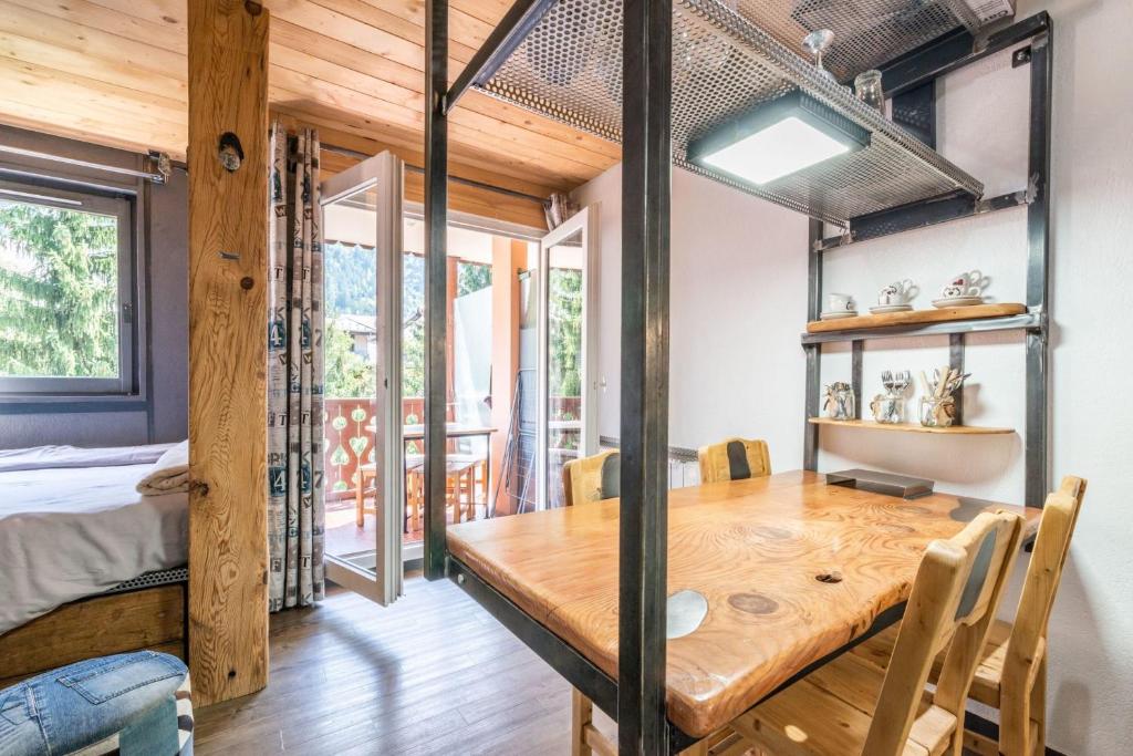 - une salle à manger avec une table en bois et un lit dans l'établissement Modern Apt with Mont-Blanc view, à Chamonix-Mont-Blanc