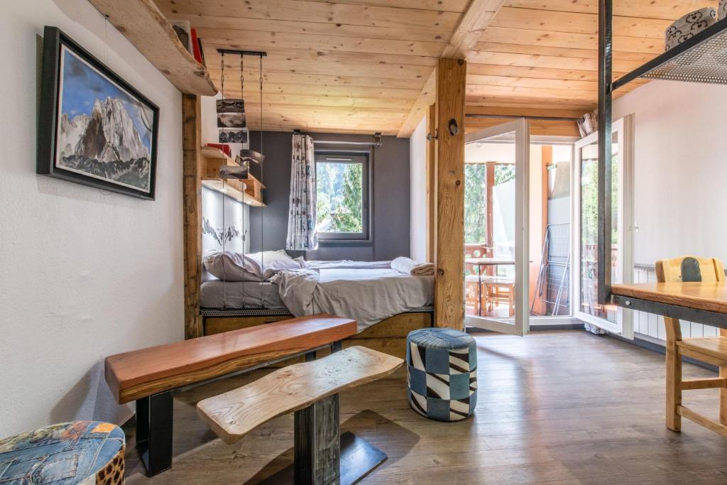 Cette chambre comprend un lit, une table et des bancs. dans l'établissement Modern Apt with Mont-Blanc view, à Chamonix-Mont-Blanc