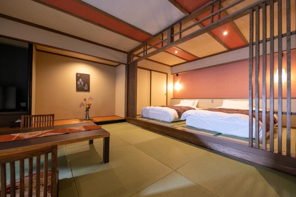 une chambre d'hôtel avec deux lits et un balcon dans l'établissement Nansuikaku, à Miyawaka