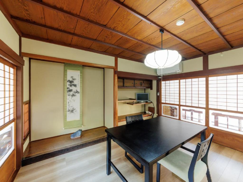 une salle à manger avec une table et des chaises noires dans l'établissement Ryokan Kigusuriya, à Nantan city