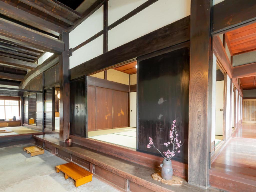 Cette chambre est dotée de murs en bois et d'un vase avec des fleurs. dans l'établissement Ryokan Kigusuriya, à Nantan city
