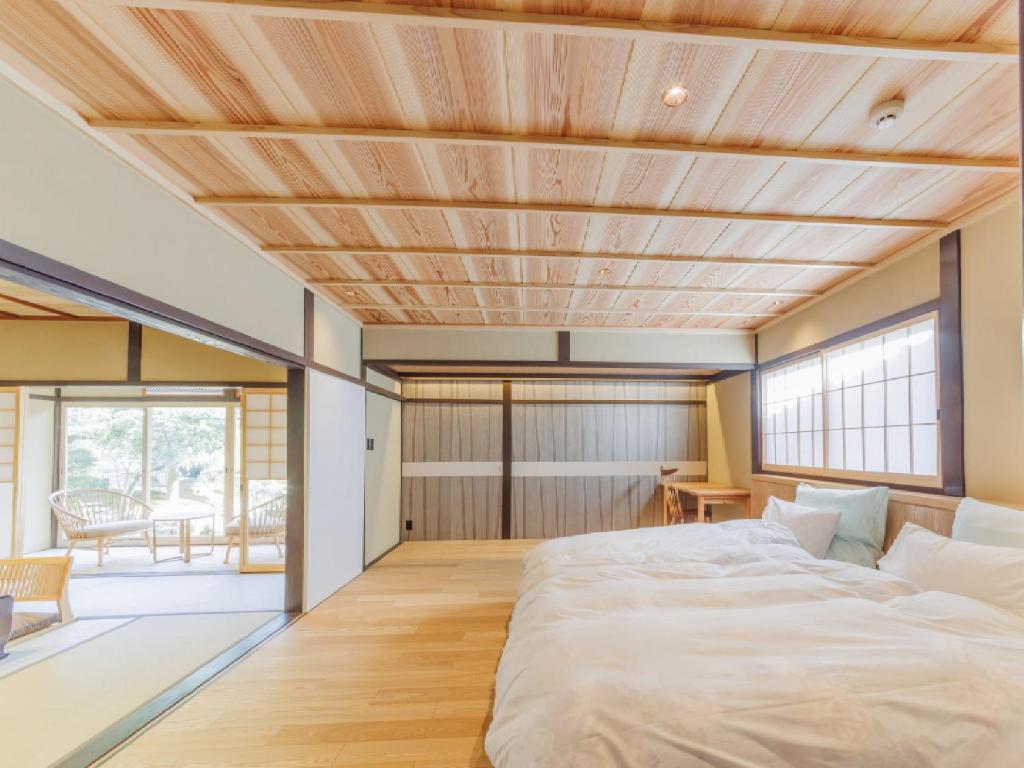 une chambre avec un grand lit avec un plafond en bois dans l'établissement Ryokan Kigusuriya, à Nantan city 37 autres photos