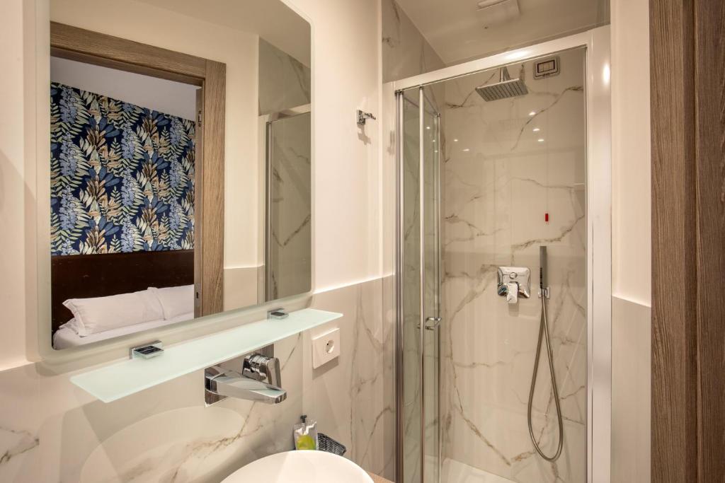 une salle de bains avec douche, lavabo et miroir dans l'établissement Hotel La Scaletta, à Lido di Ostia