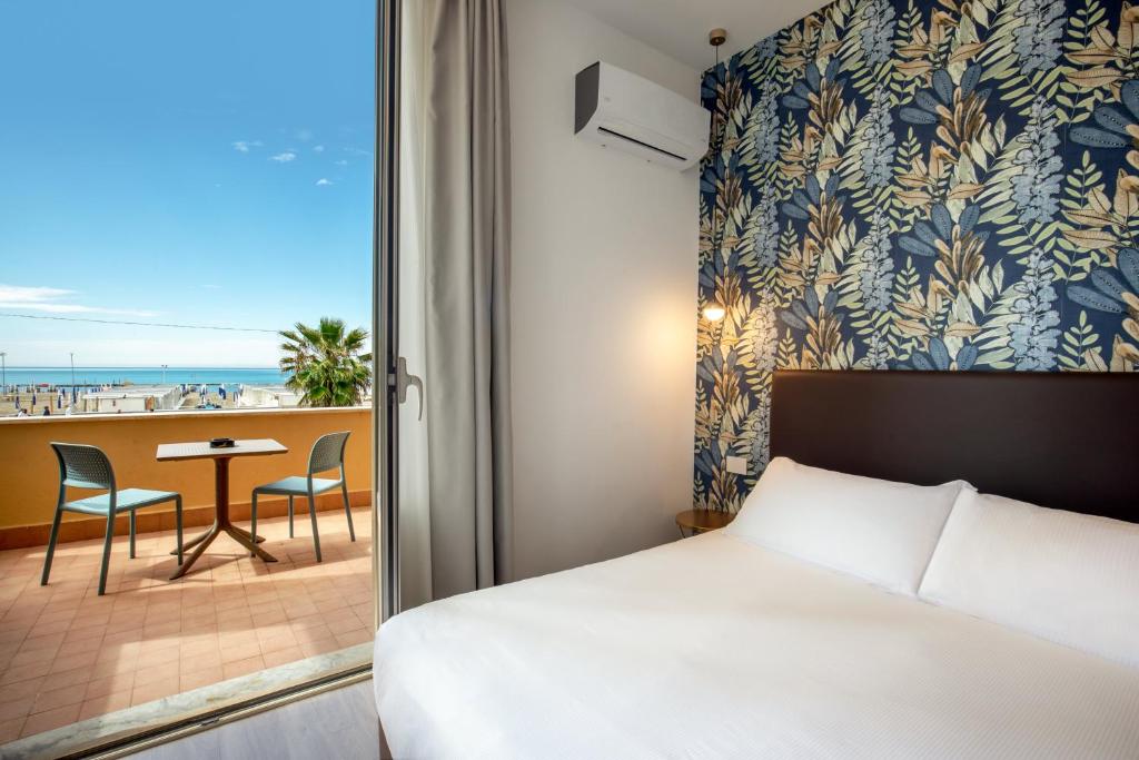 une chambre avec un lit et une vue sur la plage dans l'établissement Hotel La Scaletta, à Lido di Ostia