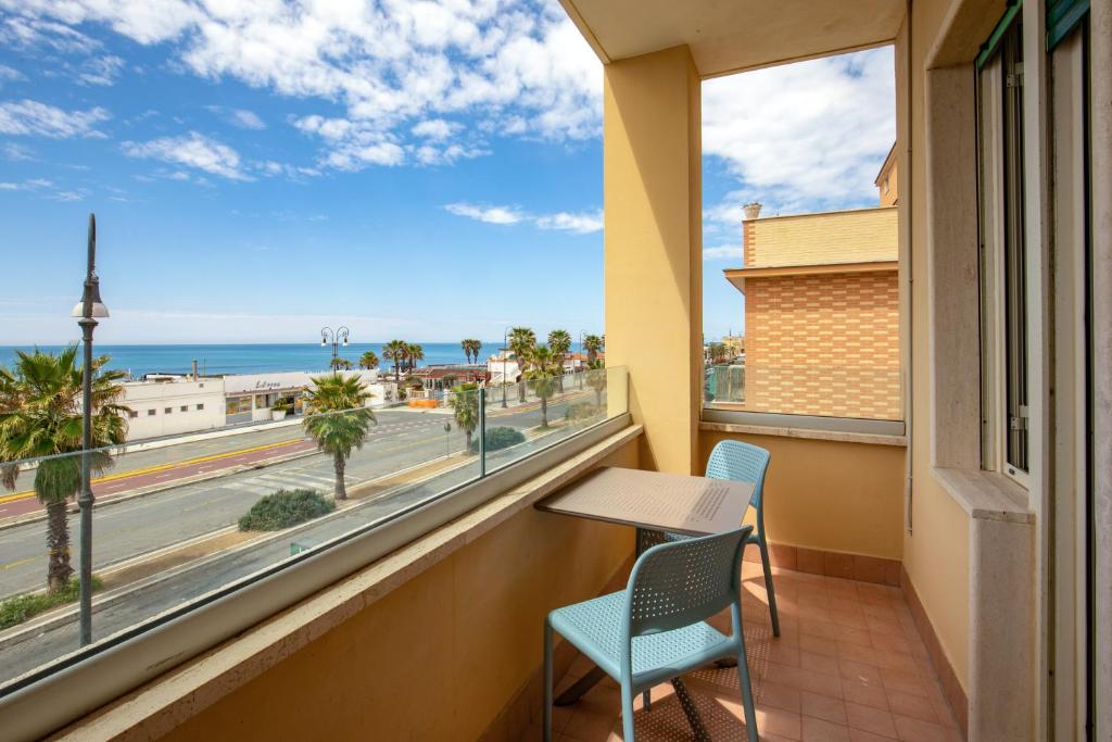 un balcon avec une table et des chaises et une vue sur l'océan dans l'établissement Hotel La Scaletta, à Lido di Ostia