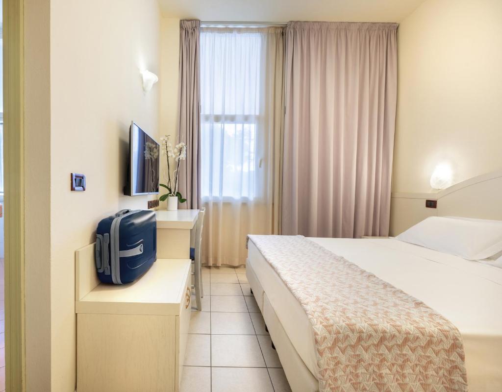 une chambre d'hôtel avec un lit et une télévision dans l'établissement Hotel Fenice Gluten Free, à Milano Marittima