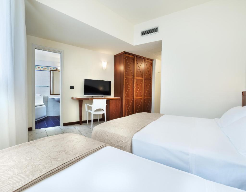 une chambre d'hôtel avec deux lits et un bureau dans l'établissement Hotel Bellevue Beach - sul mare, à Milano Marittima 75 autres photos