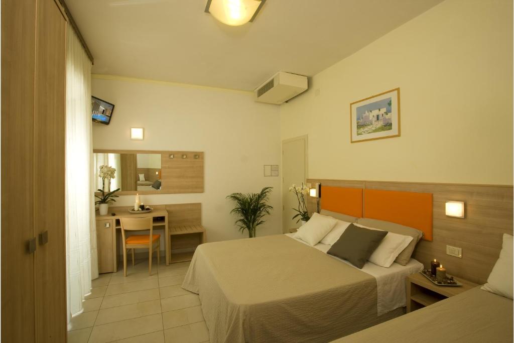 une chambre d'hôtel avec un lit et une salle à manger dans l'établissement Hotel Consuelo, à Riccione