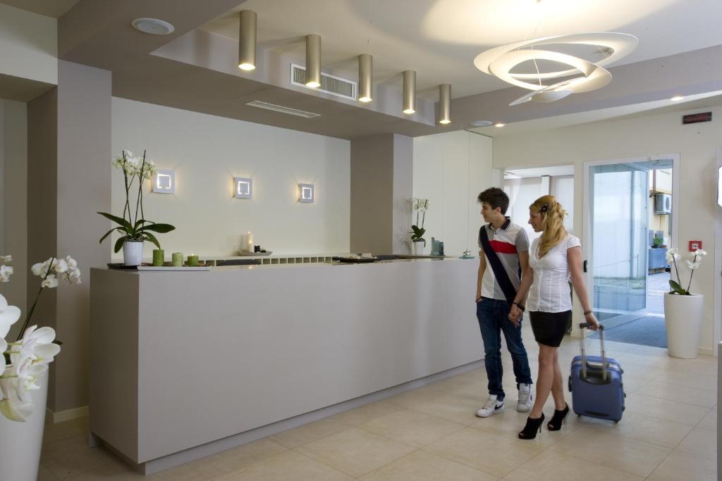 un homme et une femme debout dans un hall avec une valise dans l'établissement Hotel Consuelo, à Riccione 18 autres photos