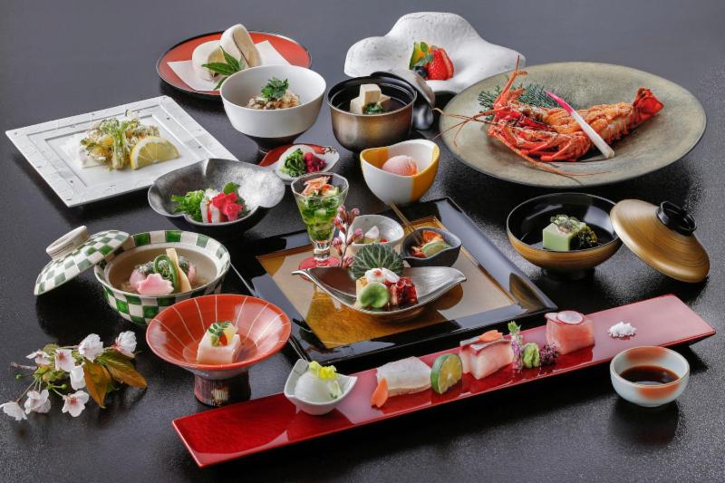 une table avec de nombreuses assiettes de nourriture dessus dans l'établissement Ryokusuitei, à Kamogawa