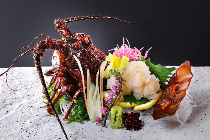 une assiette de nourriture avec un homard sur une table dans l'établissement Ryokusuitei, à Kamogawa