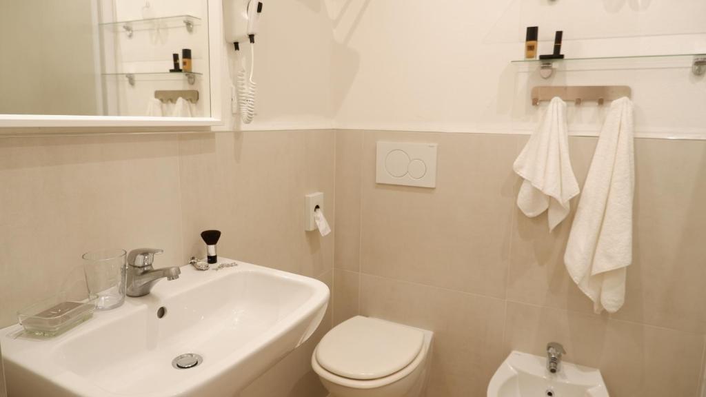 une salle de bain blanche avec un lavabo et des toilettes dans l'établissement Hotel Venezuela, à Lido di Jesolo 52 autres photos