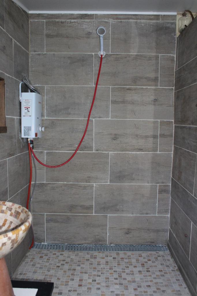 La salle de bains est pourvue d'une douche et d'un mur en briques. dans l'établissement La bulle étoile, à Allegre Les Fumades
