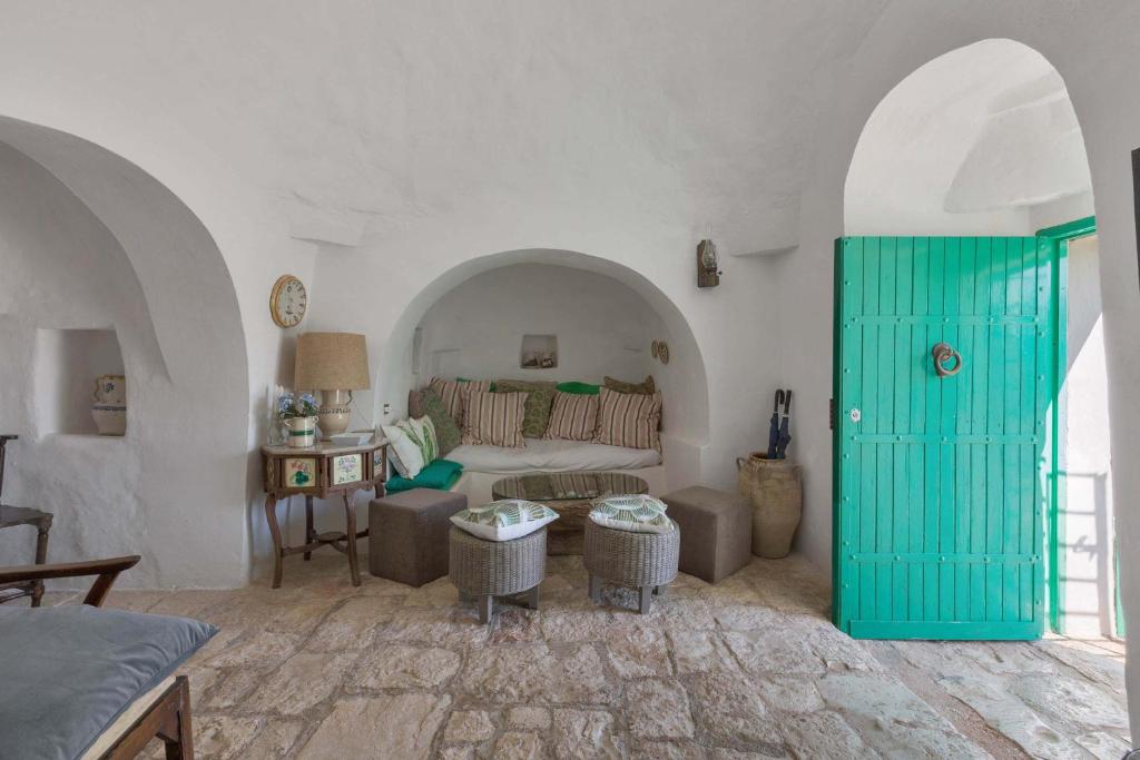 - un salon avec un lit et une porte verte dans l'établissement Trulli Il Cappero by Perle di Puglia, à Ostuni 47 autres photos