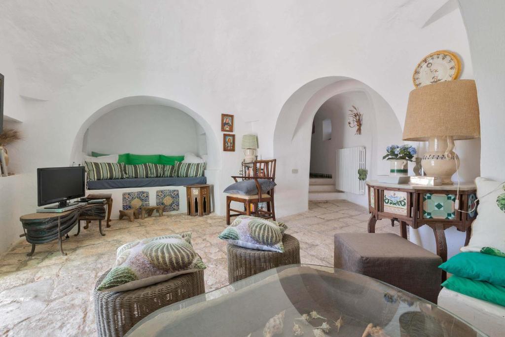 un grand salon avec un canapé et une télévision dans l'établissement Trulli Il Cappero by Perle di Puglia, à Ostuni