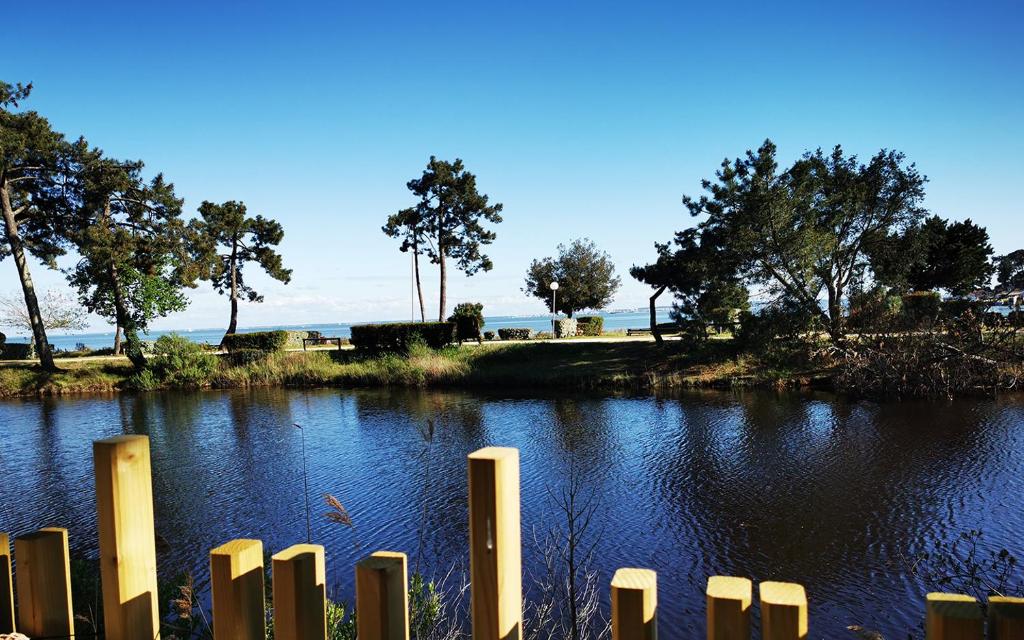 une masse d'eau avec une clôture devant elle dans l'établissement Le Bungalow du Ferret - Mobil Home Premium avec vue bassin d'Arcachon, à Claouey