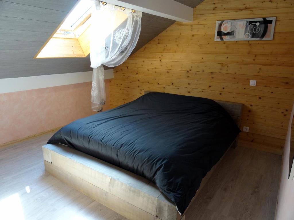 une chambre avec un lit dans une pièce avec une fenêtre dans l'établissement Gîte du cheval blanc, à Arçon