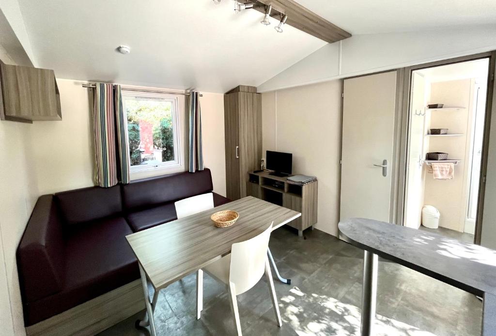 un petit salon avec une table et un canapé dans l'établissement Camping Des Mimosas, à Argelès-sur-Mer